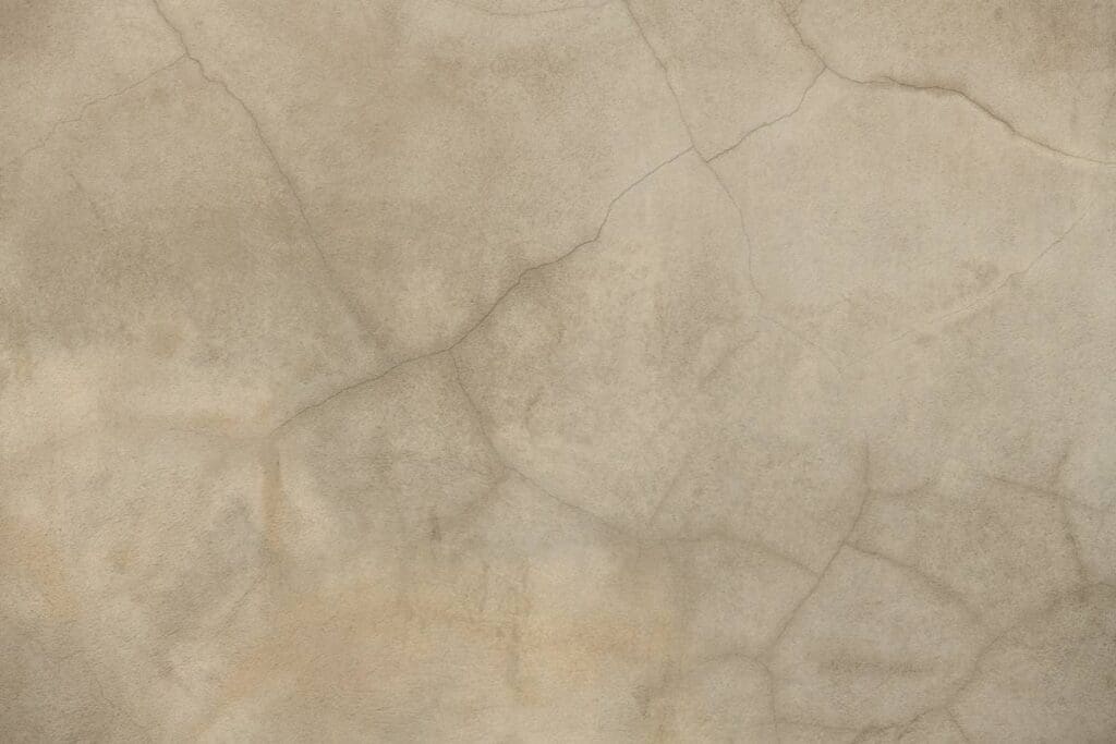 Pęknięcia tynku na elewacji domu – co może być przyczyną i jak naprawić? 1 Stare pęknięcia tynku na szarej ścianie budynku